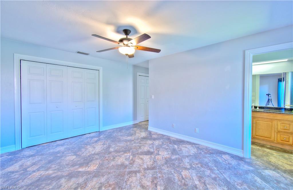 787 Palm View Drive, Unit 3 Naples, FL 34110 - Photo 24 of 27 a view of an empty room with a chandelier fan and a window
