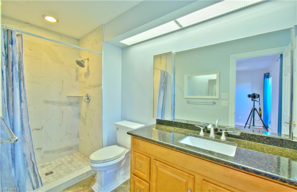 787 Palm View Drive, Unit 3 Naples, FL 34110 - Photo 25 of 27 a bathroom with a granite countertop sink toilet and shower