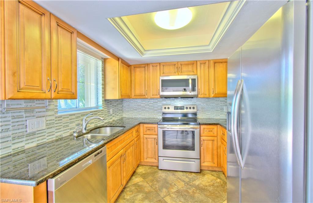 787 Palm View Drive, Unit 3 Naples, FL 34110 - Photo 9 of 27 a kitchen with stainless steel appliances granite countertop a sink stove and cabinets