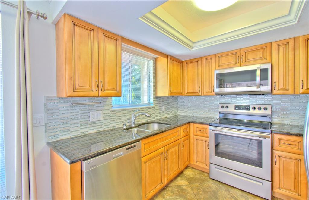 787 Palm View Drive, Unit 3 Naples, FL 34110 - Photo 10 of 27 a kitchen with stainless steel appliances granite countertop a stove sink and microwave