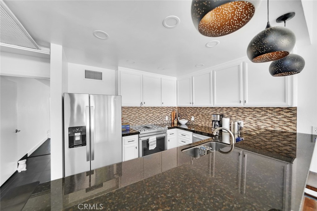 6301 Marina Pacifica Drive Long Beach, CA 90803 - Photo 5 of 39 a kitchen with stainless steel appliances granite countertop a stove and refrigerator