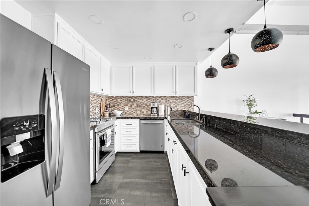 6301 Marina Pacifica Drive Long Beach, CA 90803 - Photo 7 of 39 a kitchen with stainless steel appliances granite countertop a sink a stove and refrigerator