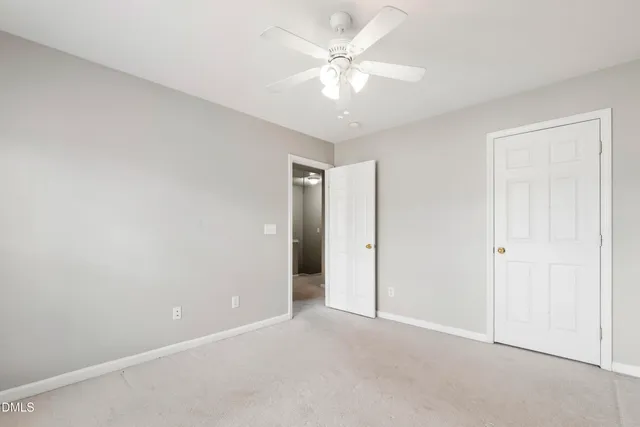 an empty room with a ceiling fan and a window