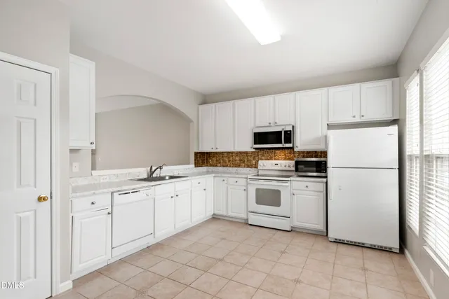 a kitchen with white cabinets sink and white appliances