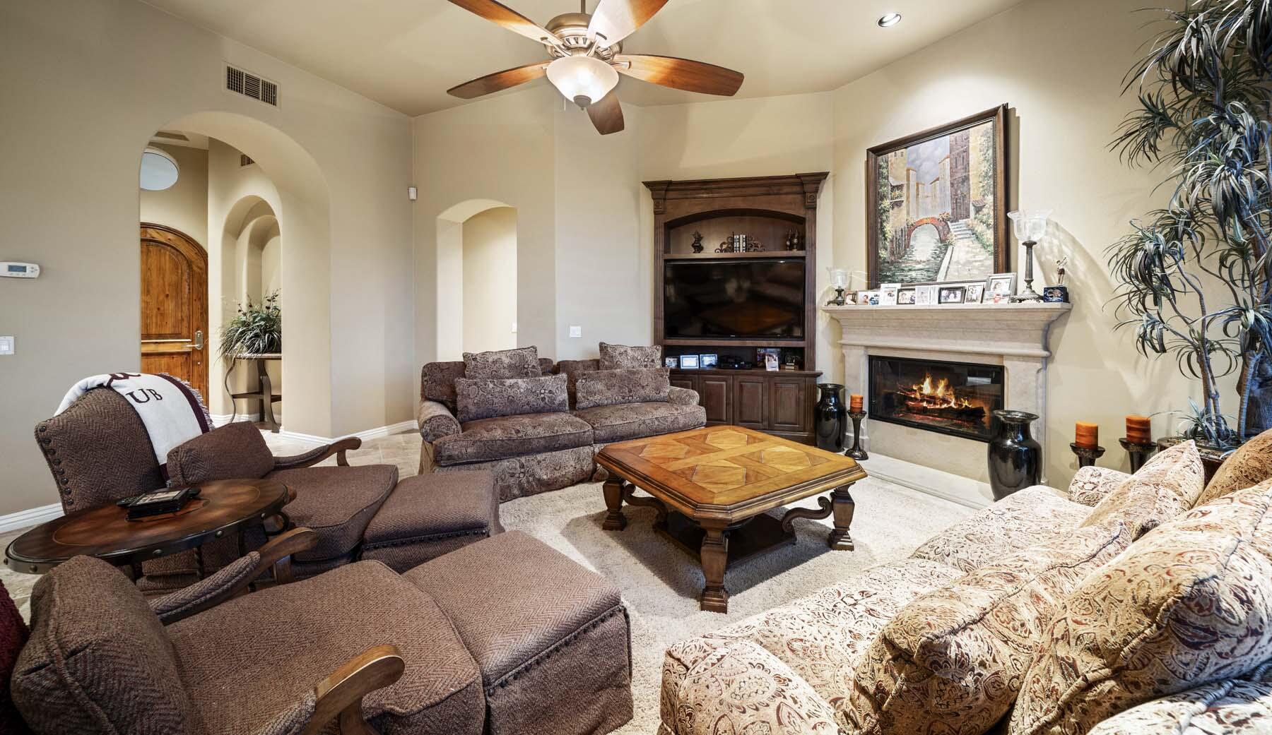 76128 Via Firenze Indian Wells, CA 92210 - Photo 36 of 67 a living room with couches a fireplace and a flat screen tv