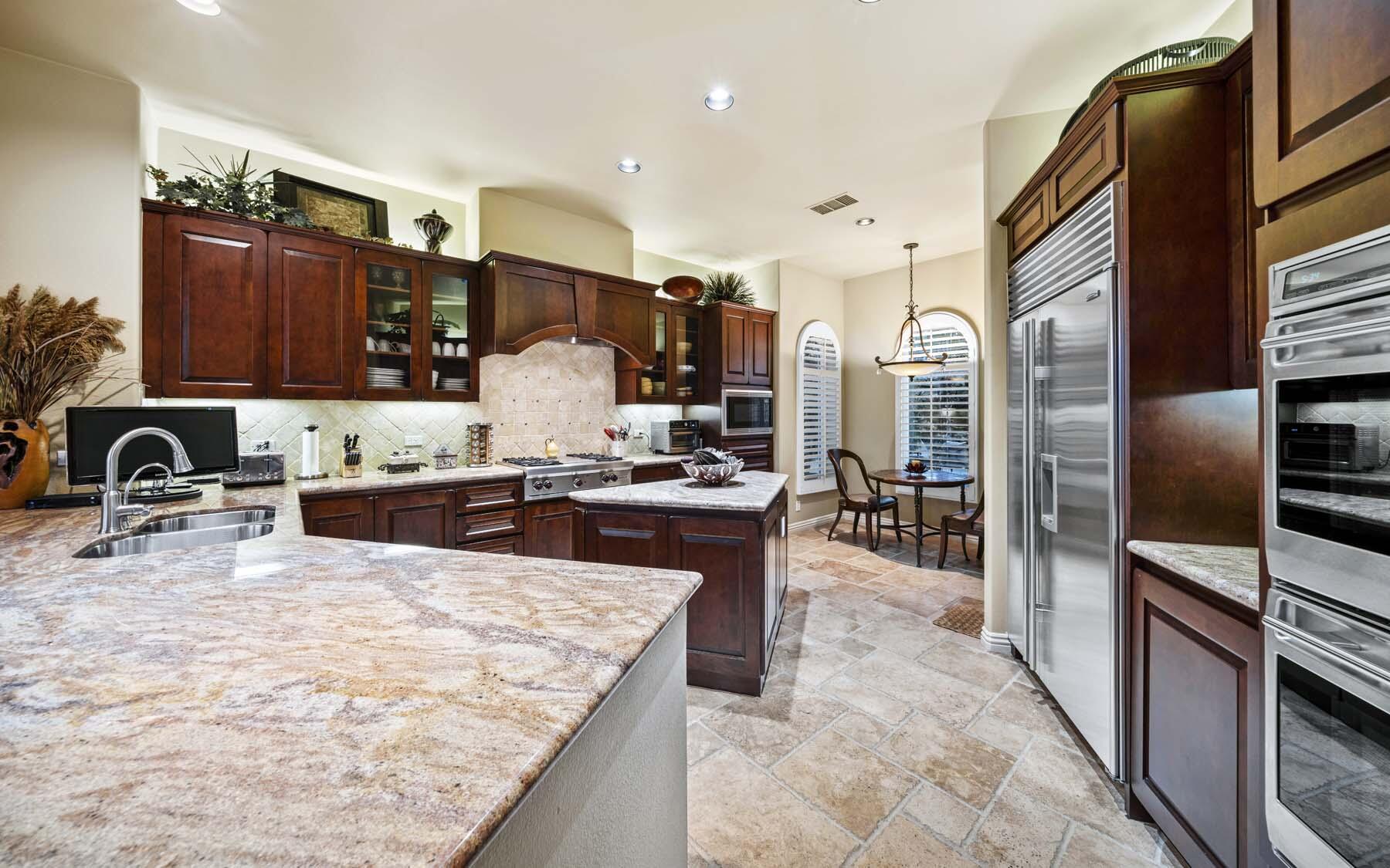 76128 Via Firenze Indian Wells, CA 92210 - Photo 39 of 67 a kitchen with stainless steel appliances granite countertop a sink refrigerator and cabinets