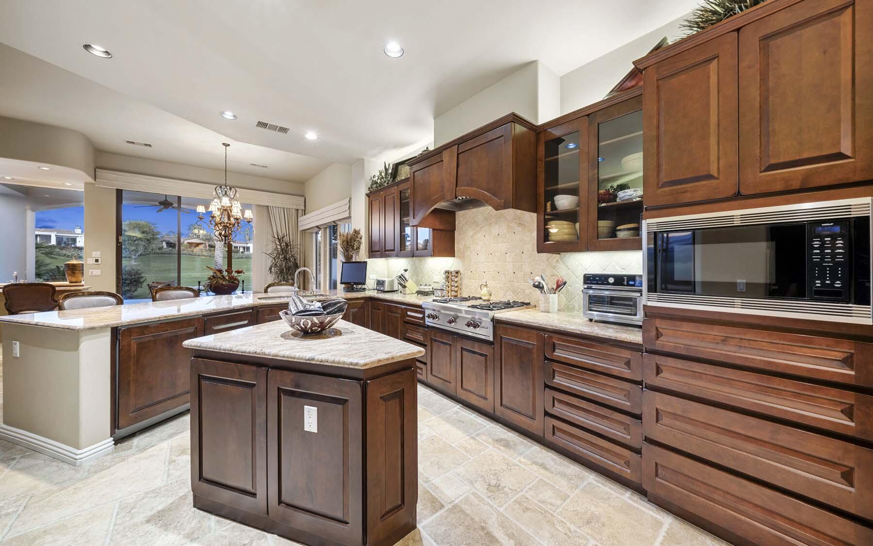 76128 Via Firenze Indian Wells, CA 92210 - Photo 42 of 67 a kitchen with stainless steel appliances granite countertop a sink stove and a wooden cabinets