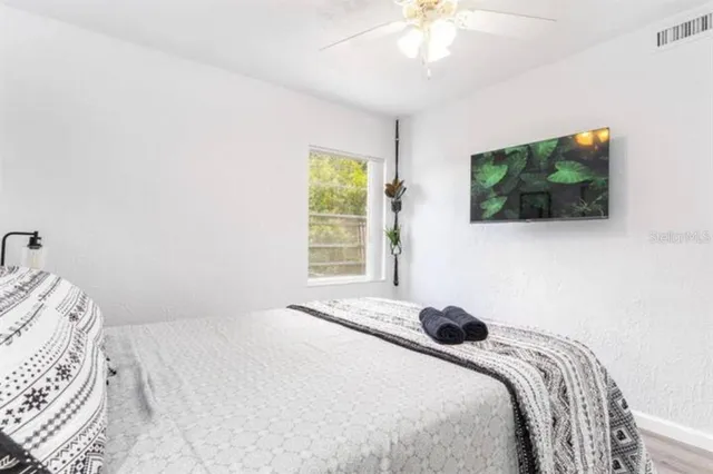 a bedroom with a bed and a flat screen tv