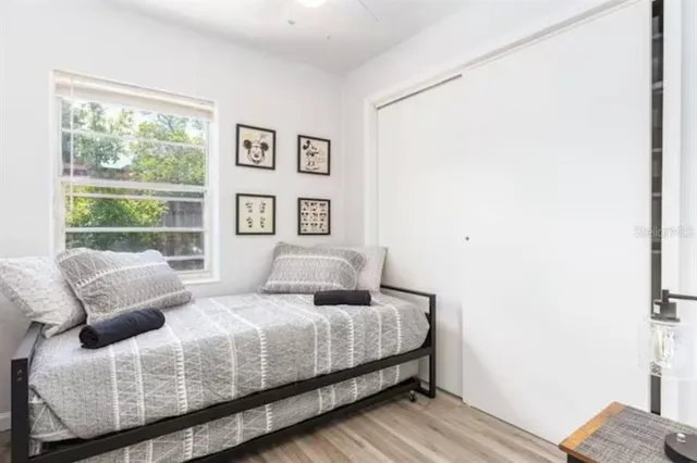 a bedroom with a bed and wooden floor