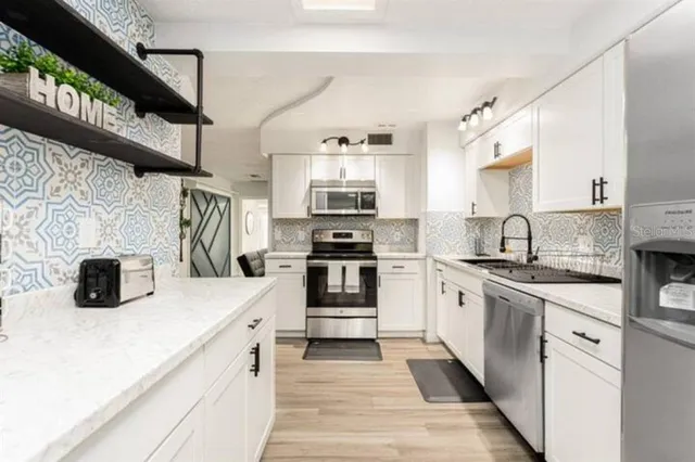 a kitchen with stainless steel appliances granite countertop a sink and a stove