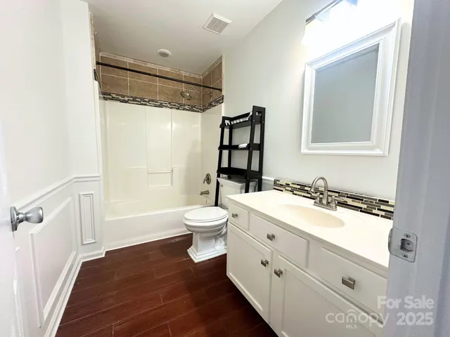 a bathroom with a double vanity sink toilet mirror and shower