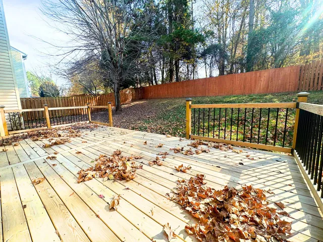 a view of backyard with wooden fence and trees