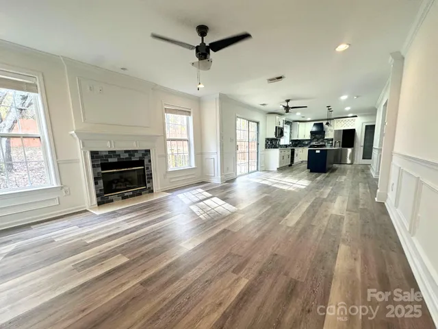 a view of a livingroom with furniture a flat screen tv and fireplace