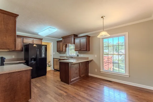 a kitchen with kitchen island granite countertop wooden floors and stainless steel appliances