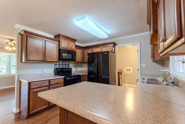 a kitchen with stainless steel appliances granite countertop a refrigerator stove microwave and sink