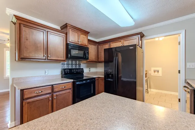 a kitchen with granite countertop stainless steel appliances cabinets and a counter top space