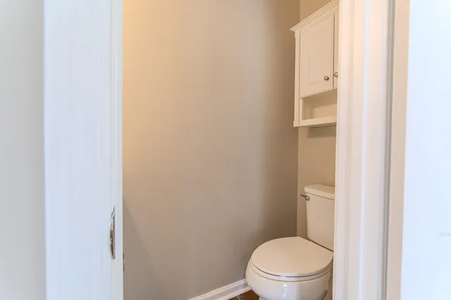 a white toilet sitting next to a shower