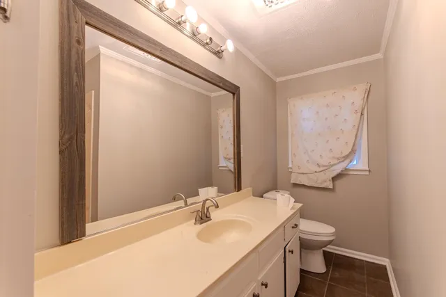 a bathroom with a sink mirror vanity and toilet