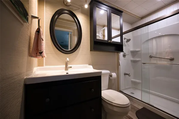 a bathroom with a toilet a sink and a mirror