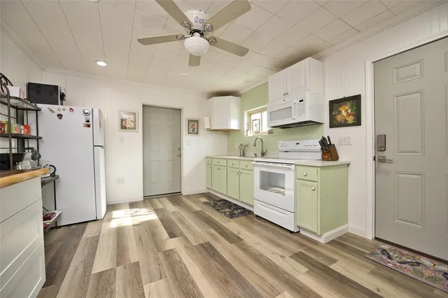 a kitchen with a refrigerator a stove top oven a sink and cabinets