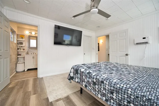 a spacious bedroom with a bed and a flat screen tv