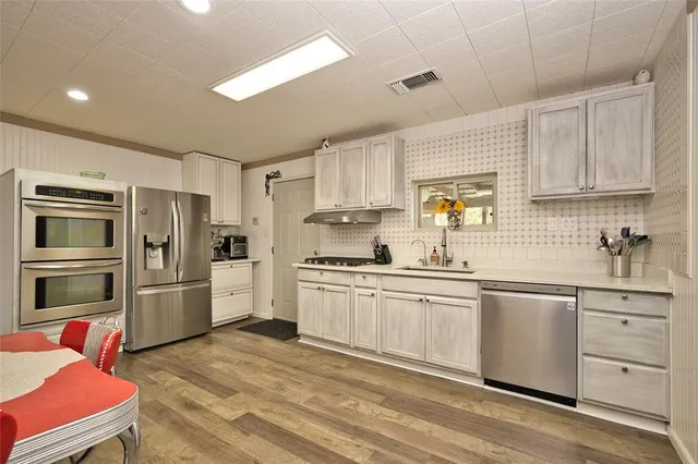 a kitchen with stainless steel appliances a refrigerator sink and cabinets