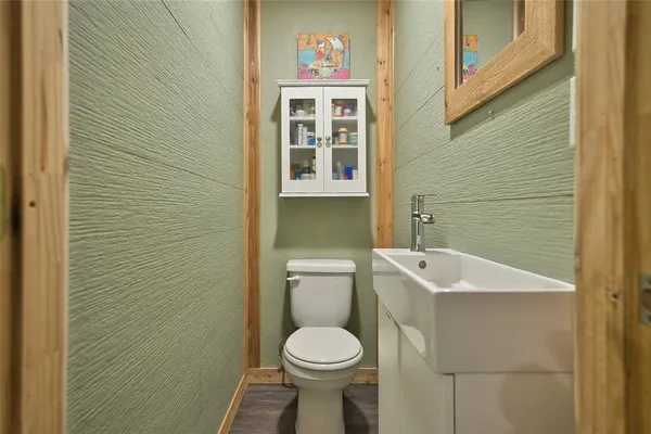 a bathroom with a toilet sink and mirror