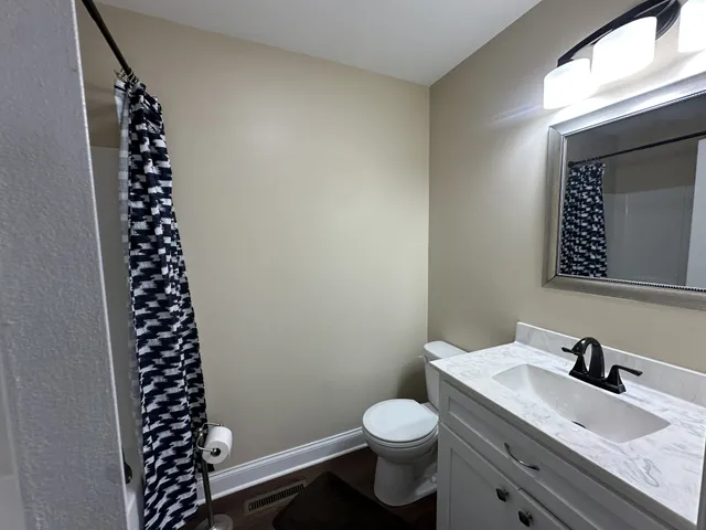 a bathroom with a sink a toilet and a mirror