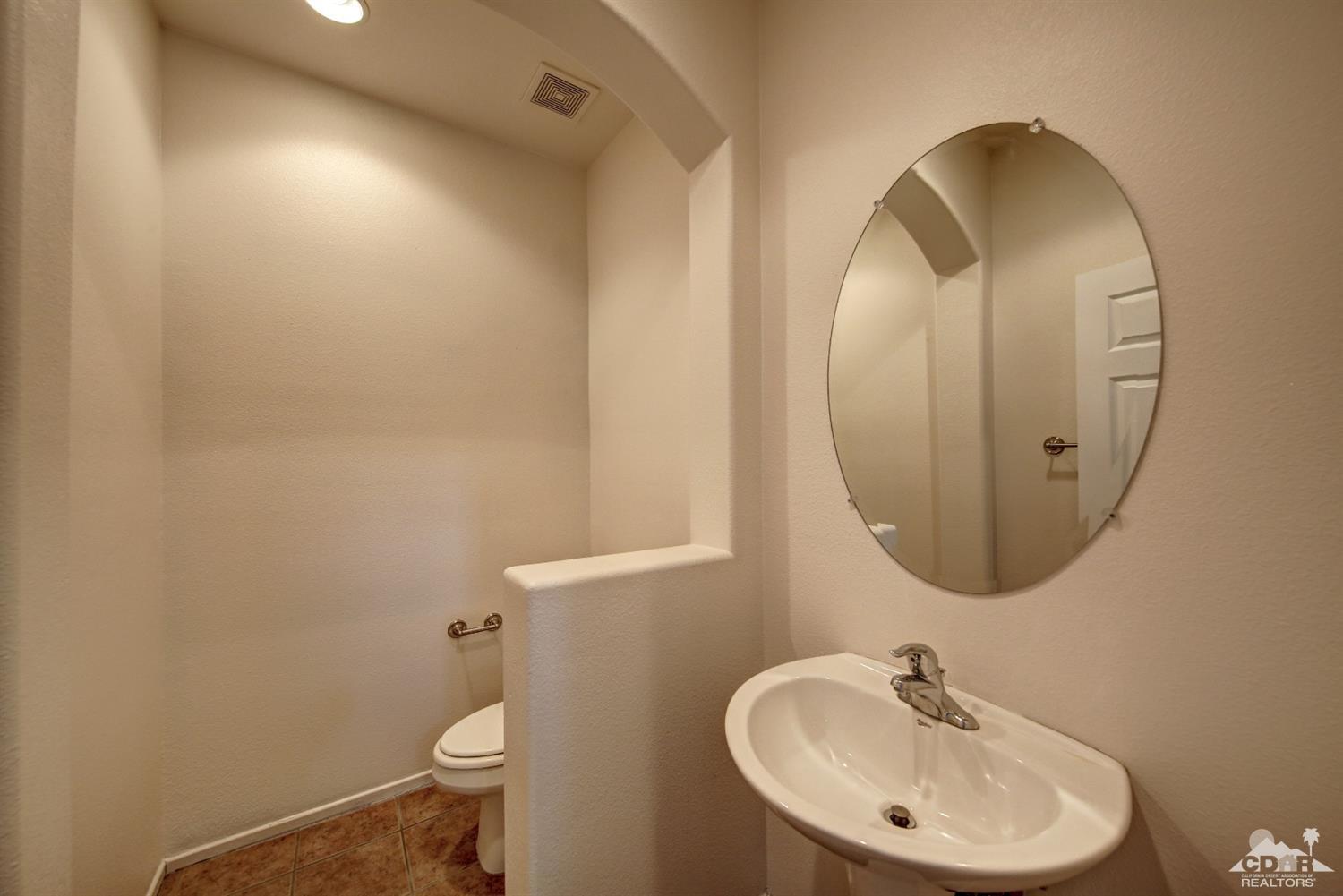 83275 Lightning Road Indio, CA 92203 - Photo 24 of 28 a bathroom with a sink mirror and toilet