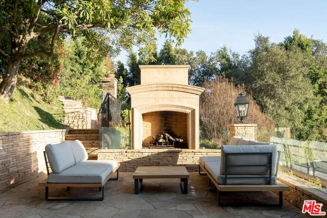 a view of a patio with couches and a fireplace