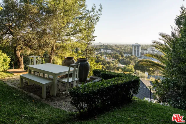 a view of a garden with houses in back