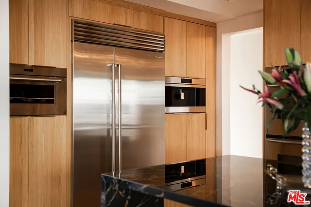 a kitchen with a refrigerator and a stove top oven