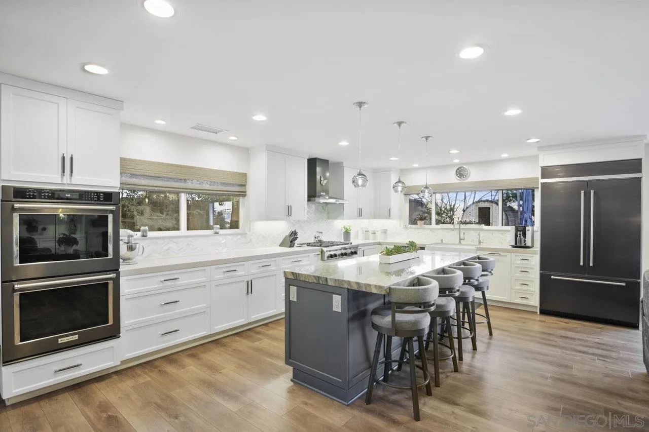 1353 Eastside Road El Cajon, CA 92020 - Photo 11 of 43 a kitchen with stainless steel appliances kitchen island granite countertop a stove top oven a sink dishwasher a dining table and chairs with wooden floor