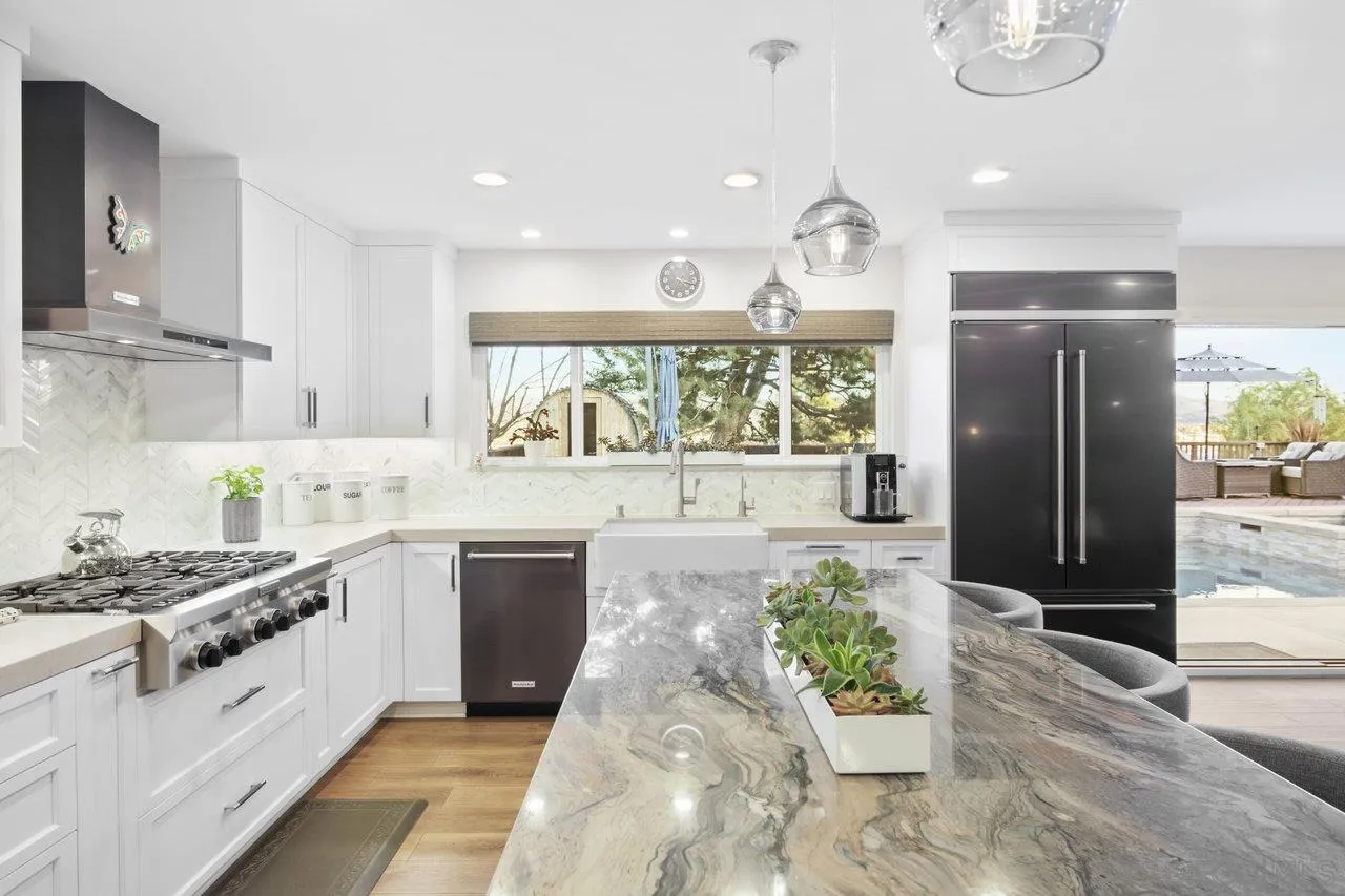 1353 Eastside Road El Cajon, CA 92020 - Photo 12 of 43 a kitchen with stainless steel appliances kitchen island granite countertop a stove a sink and a refrigerator