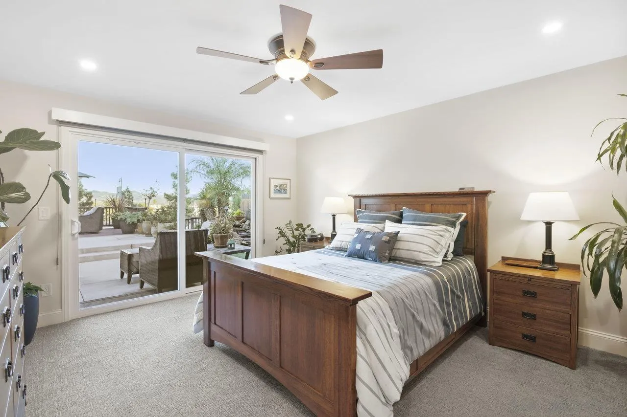 1353 Eastside Road El Cajon, CA 92020 - Photo 17 of 43 a bedroom with a large bed and a chandelier fan