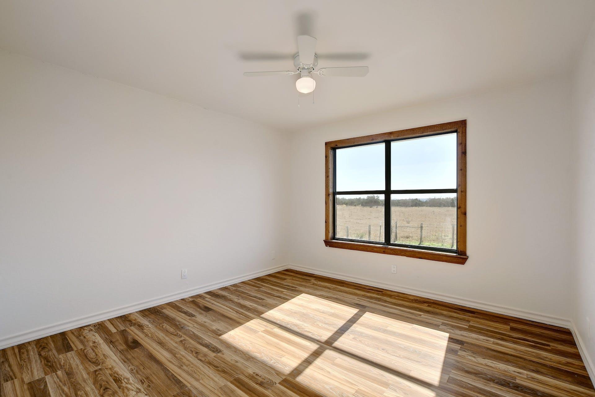 501 Myers Creek Road Dripping Springs, TX 78620 - Photo 16 of 33 Gleaming wood floors anchor this bedroom while a large window frames tranquil pasture views.