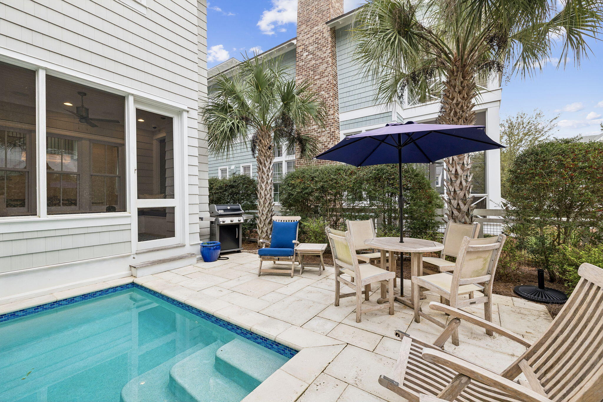 17 Compass Point Way Watersound, FL 32461 - Photo 70 of 73 a view of a patio with a table and chairs under an umbrella with a barbeque