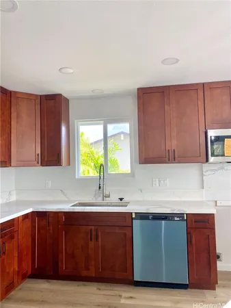 a kitchen with wooden cabinets a sink and a window