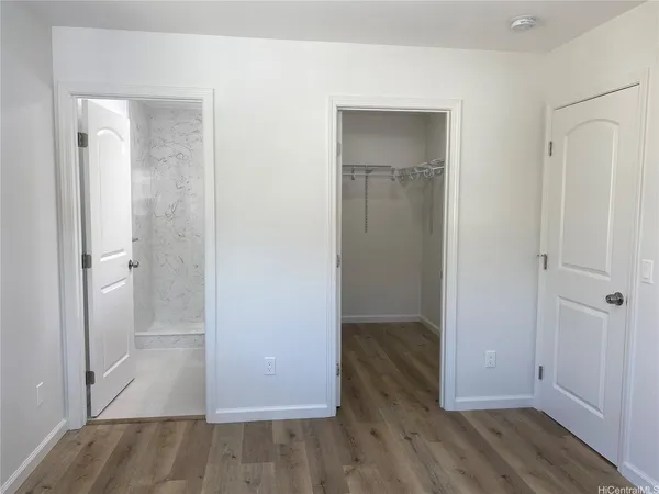 an empty room with wooden floor & closet area