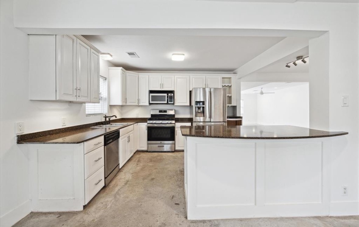 3818 Childress Street Houston, TX 77005 - Photo 2 of 10 a kitchen with granite countertop white cabinets and white appliances