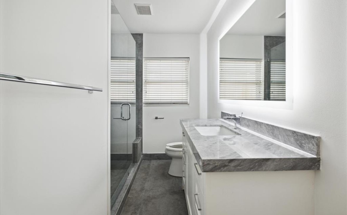 3818 Childress Street Houston, TX 77005 - Photo 7 of 10 a bathroom with a granite countertop sink and a mirror