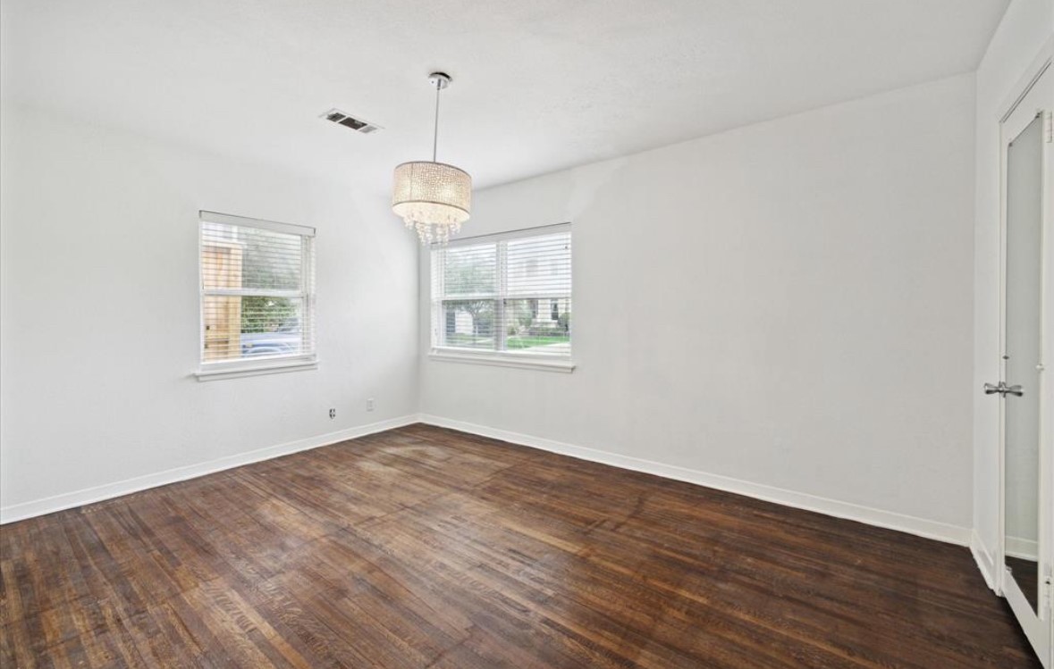 3818 Childress Street Houston, TX 77005 - Photo 8 of 10 an empty room with wooden floor chandelier and windows