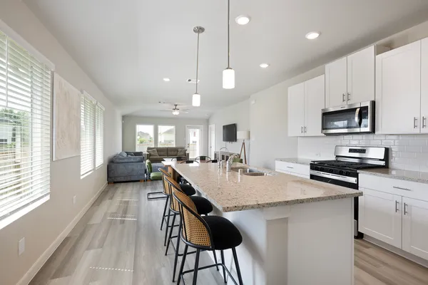 a kitchen with sink a counter and chairs