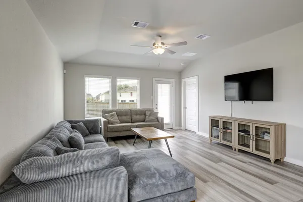 a living room with furniture and wooden floor