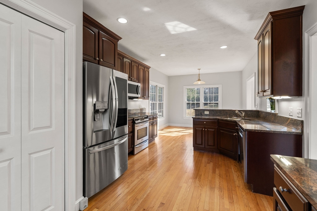 40 Sandy Ridge Road Sterling, MA 01564 - Photo 8 of 33 a kitchen with stainless steel appliances granite countertop a refrigerator a sink dishwasher a stove and a oven with wooden floor