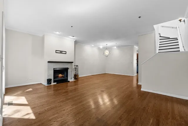 a view of empty room with wooden floor and fireplace