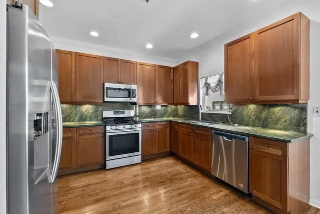 a kitchen with stainless steel appliances granite countertop a refrigerator and a stove top oven