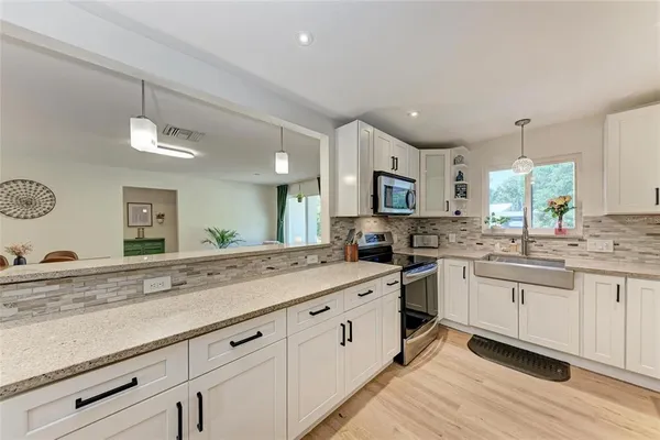 a kitchen with white cabinets appliances and a sink