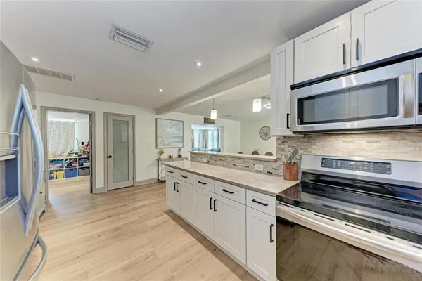a kitchen with stainless steel appliances kitchen island granite countertop a stove and cabinets