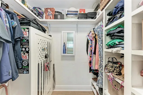 a view of walk in closet with clothes and shoes